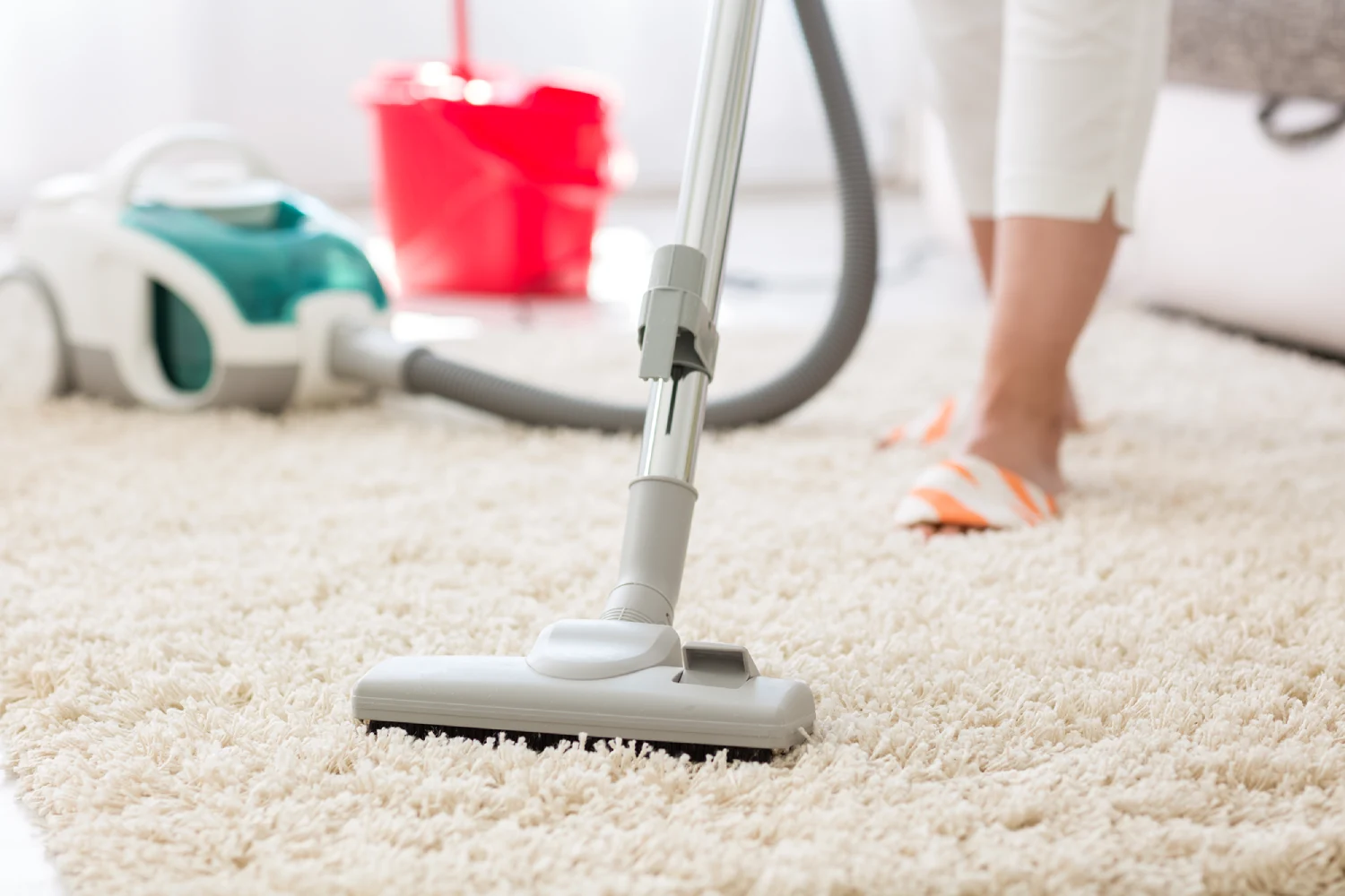 Vacuum cleaning a carpeted floor at home.